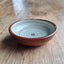 Ceramic bowl with concentric circle pattern on a wooden surface