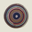 Round woven rug with multicolored concentric circles on a beige background