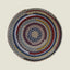 Round braided rug with multicolor concentric circles on a beige background