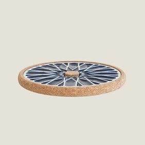 Round ceramic trivet with cork base on a white background