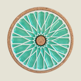 Round coaster with teal and white design on a beige background