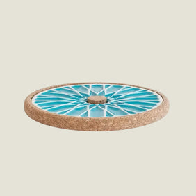 Round cork coaster with a blue and white pattern on a white background