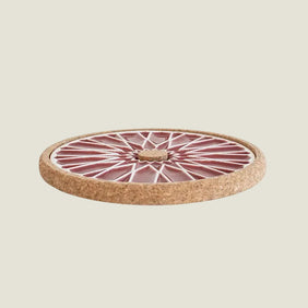 Round ceramic trivet with cork base on a white background