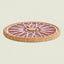 A round cork trivet or coaster with a pink and white geometric fan pattern, shown on a light beige background.