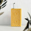 Yellow oil dispenser with intricate patterns on a white surface