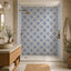 A modern bathroom interior featuring a walk-in shower area with portuguese blue and white patterned tile walls, a wooden vanity with a stone countertop, a round vessel sink, and neutral-toned textiles and plants.