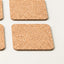 Square cork coasters with rounded corners, shown in a close-up studio shot on a light neutral background.