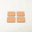 Four rectangular cork coasters with rounded corners arranged in a 2x2 grid on a plain white background.