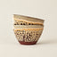 Two stacked ceramic bowls with a speckled brown and beige pattern and a glossy finish, set against a plain light beige background.
