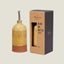 Olive oil bottle with decorative pattern and packaging displaying brand name on a beige background