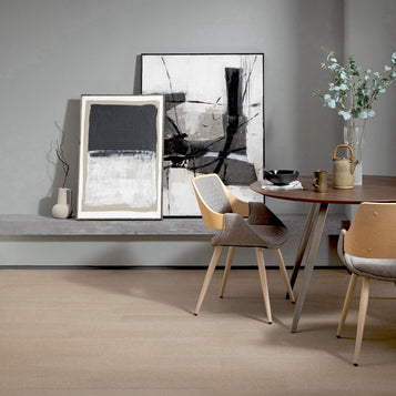 Modern dining room with abstract art, table, and chairs.